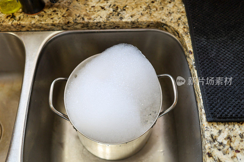 一个浸泡在厨房水槽里的不锈钢锅