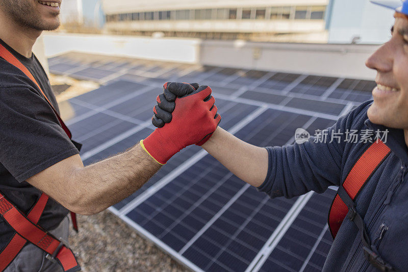 工人们与太阳能电池板握手