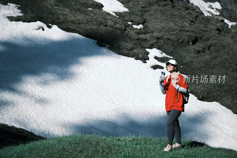 女徒步旅行者正在山里喝水