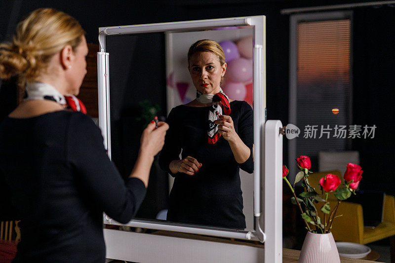 一个快乐的女人站在镜子前，用红色的口红画着一颗心