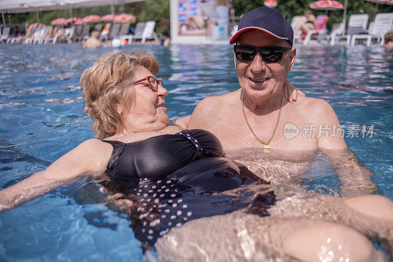 可爱的老夫妇在游泳池