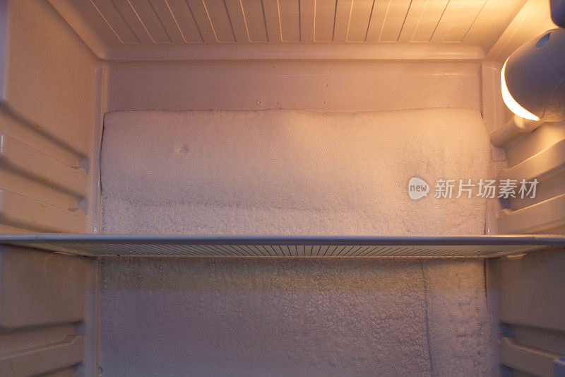 冰箱坏了，里面有雪，需要修理。冰箱后墙上的糖霜。冰箱在维修车间维修。冰箱内部视图。维修有故障的制冷设备