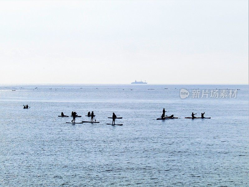 日本。有冲浪者剪影的海景。