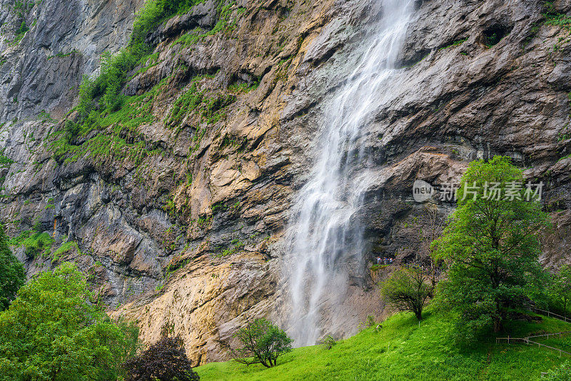 在一个晴朗的夏日，瑞士Lauterbrunnen村的Staubbachfall瀑布。高山旅游村庄Lauterbrunnen令人惊叹的景观。以高悬崖为背景的著名旅游村。