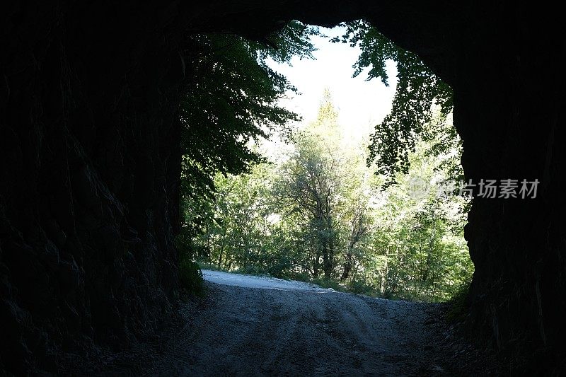 从岩石上凿出的隧道底部可以看到绿树。