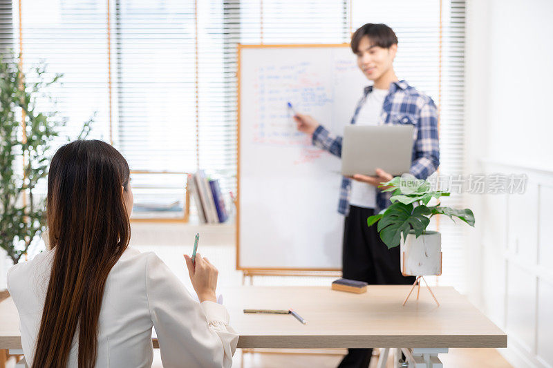 商务人士在家庭办公室向合作伙伴介绍新项目。一个年轻的商人在会议室里做报告。