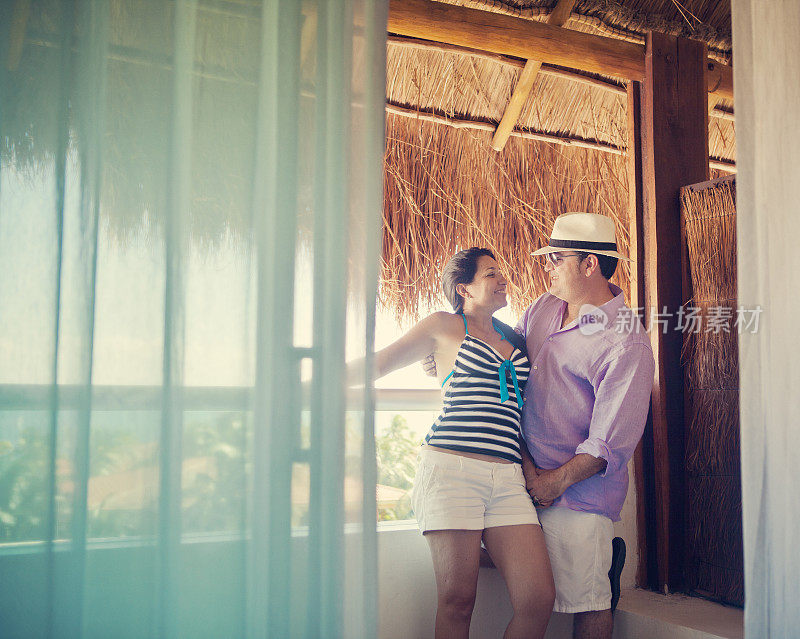 一对中年西班牙夫妇站在酒店度假阳台上