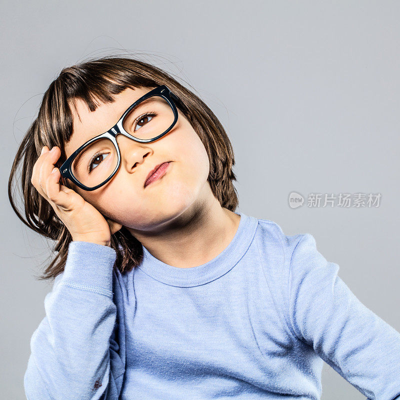 严重的学龄前儿童，戴着眼镜思考，想象，困惑或头痛