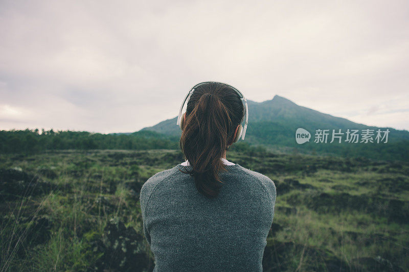 女人戴着耳机在大自然中听音乐