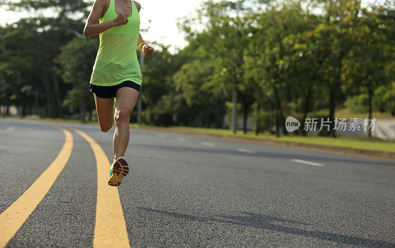 年轻的健身女运动员在公路上跑步