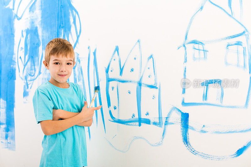 男孩在墙上画了一座房子