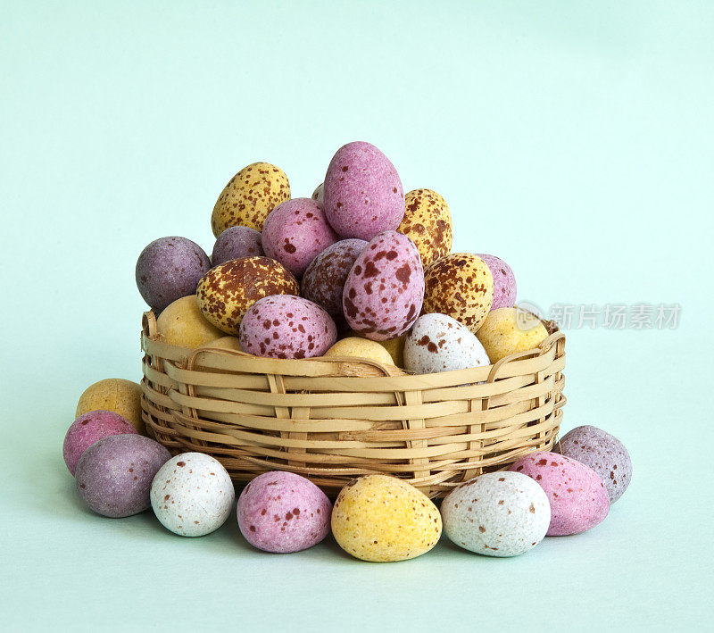 带斑点的巧克力迷你复活节彩蛋在篮子里和周围
