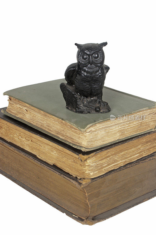 三本古书与猫头鹰雕像的垂直堆叠