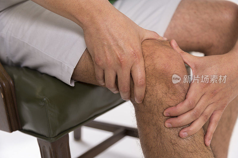 疼痛:男人在按摩他疼痛的膝盖。