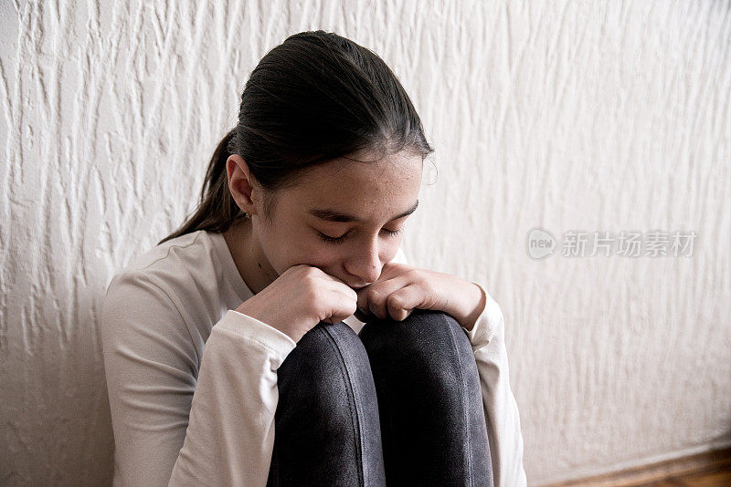 坐在卧室里的沮丧少女