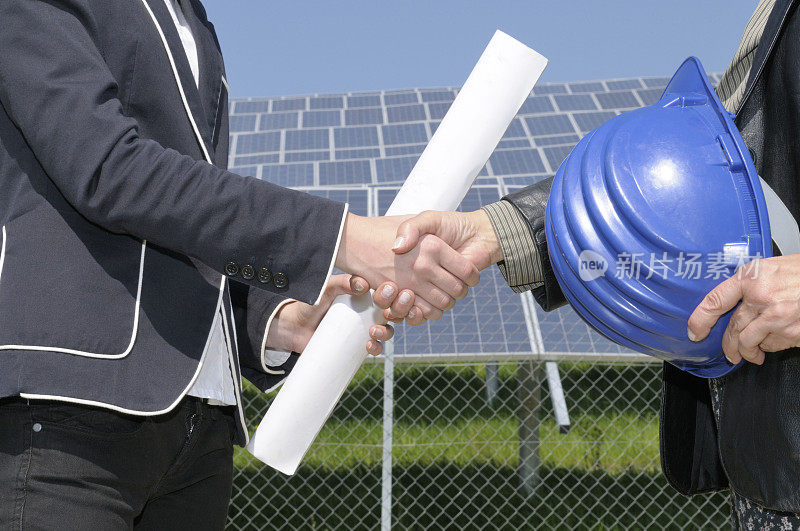 在太阳能发电站握手的女工程师