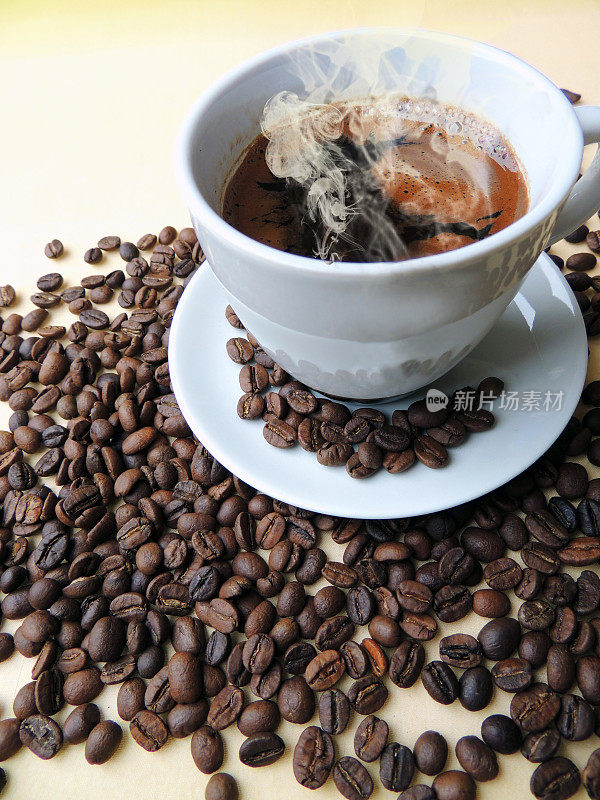 一杯热气腾腾的咖啡夹在咖啡豆中
