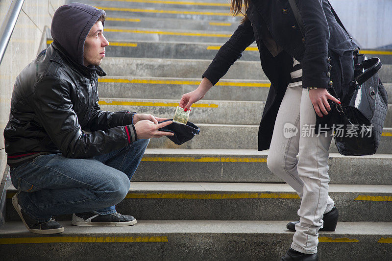 年轻的街头乞丐……乞讨在楼梯……女人给了他一些现金