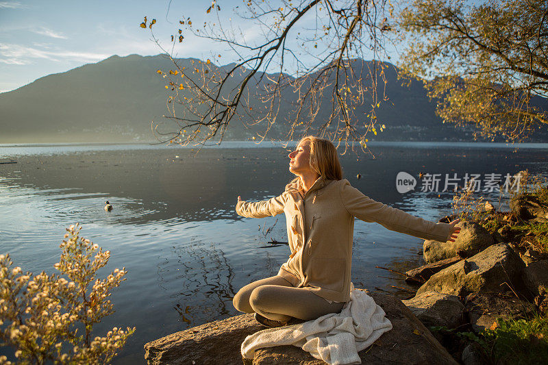 快乐的女人在湖边享受大自然