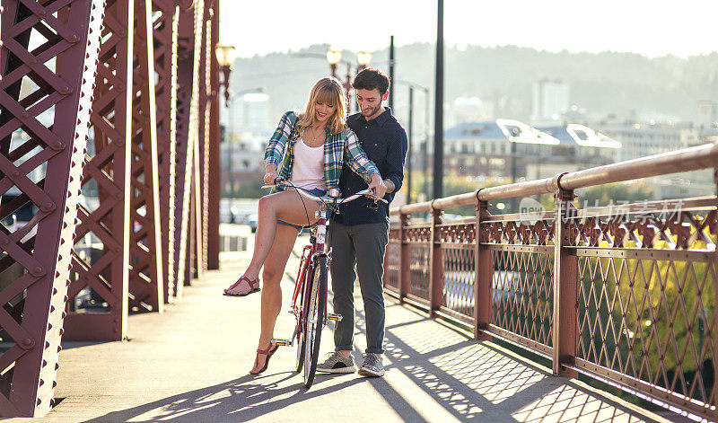 一名成年男子在帮女友骑自行车