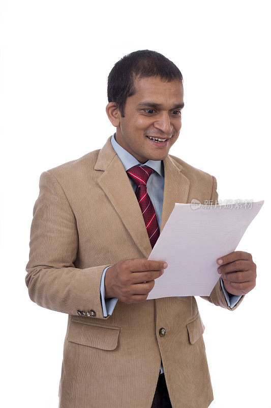 快乐的年轻印度商人在读一张纸