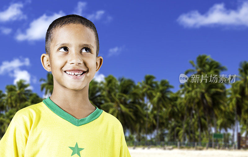 一个巴西小男孩在热带背景下微笑