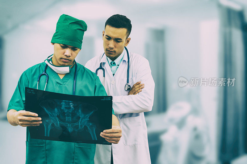 外科医生和医生在看x光片。