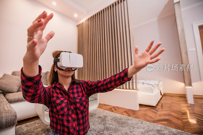 年轻女子在家里使用虚拟现实模拟器