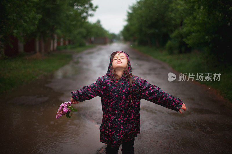 小女孩在雨中行走在乡村