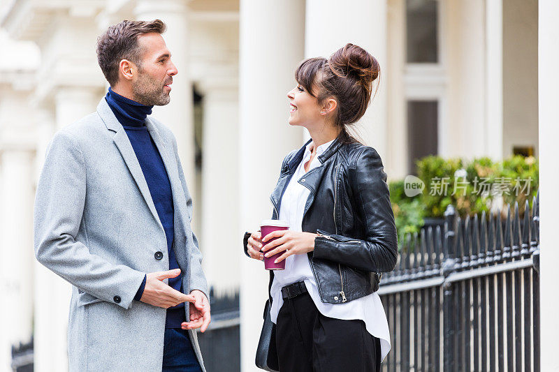 时髦随意的情侣在伦敦的城市街道上聊天