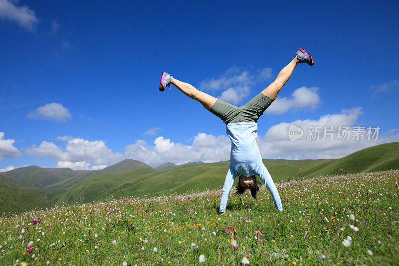 倒立女子在山顶草地嬉戏