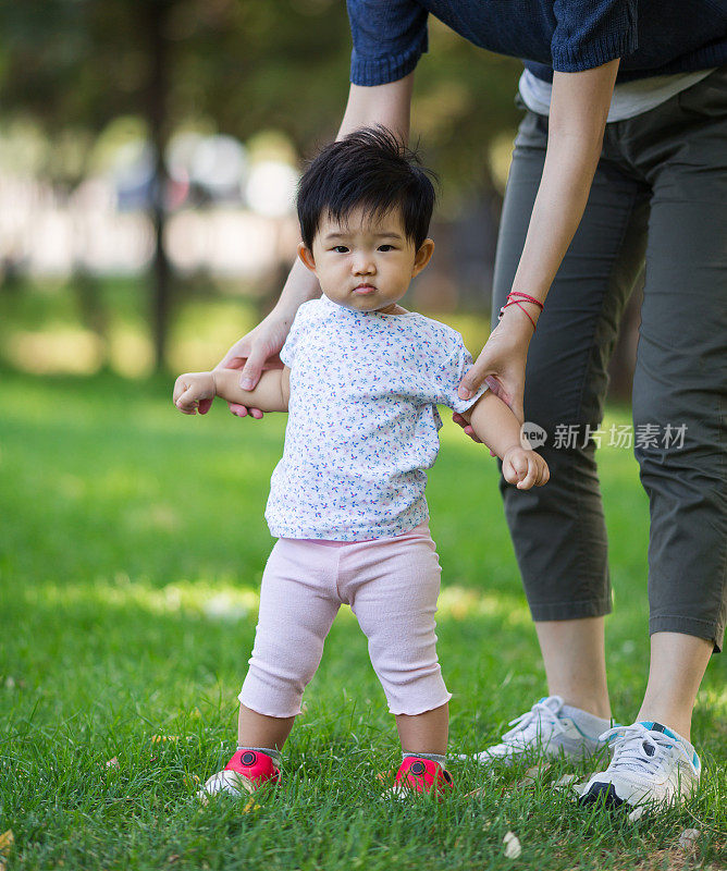 母亲帮助婴儿迈出生命的第一步