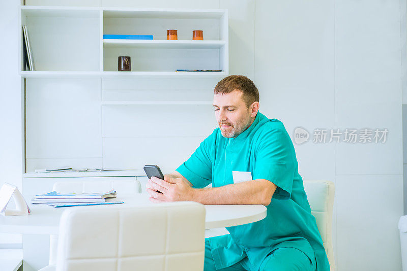 医生使用移动智能手机，坐在医院医务室，电子病历系统ehr，远程会议或远程医疗，云存储技术概念。副本的空间。