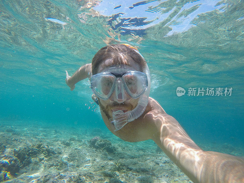 一名年轻人戴着潜水面罩在水下自拍