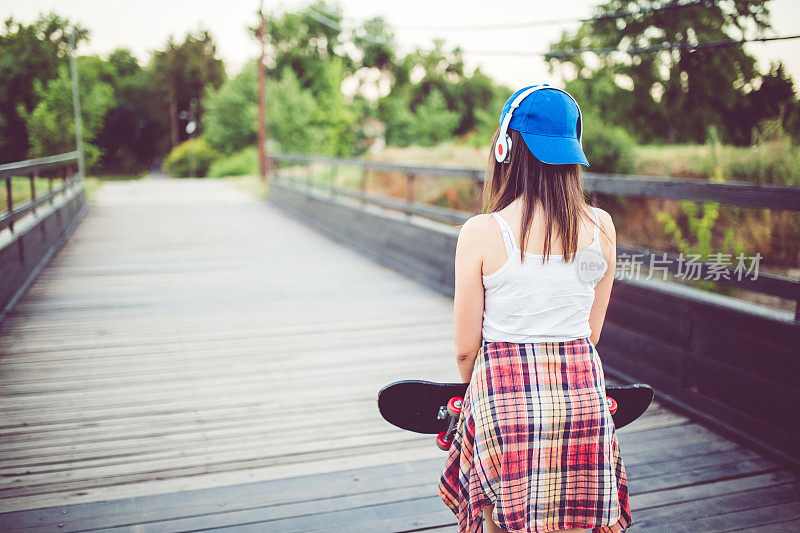 桥上的女孩拿着滑板