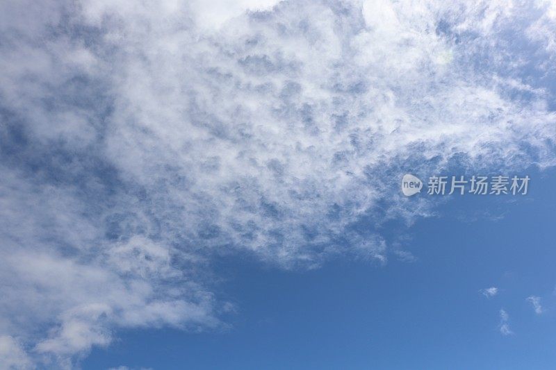 蓝色的天空中，蓬松、缕缕的白色积云