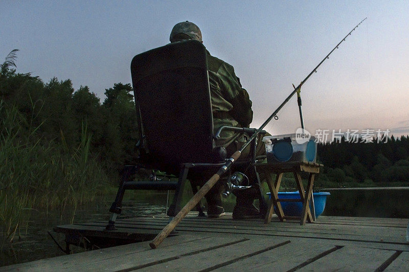 一个男人在黄昏时分钓鱼。