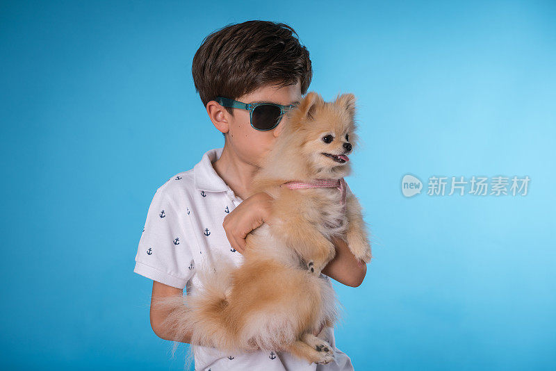 快乐的男孩和她的博美犬斯皮茨型狗