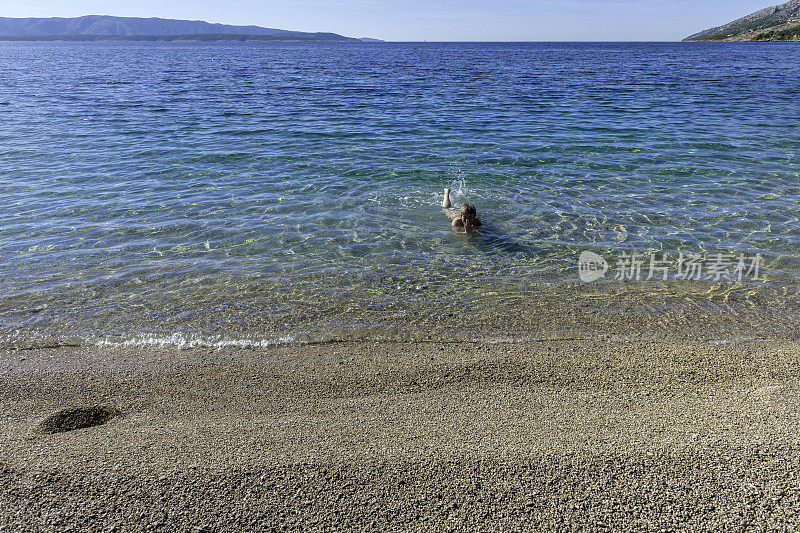 成熟的女人游泳在亚得里亚海，布拉克，地中海，克罗地亚，欧洲