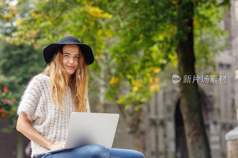 美丽的荷兰女大学生在校园里使用笔记本电脑