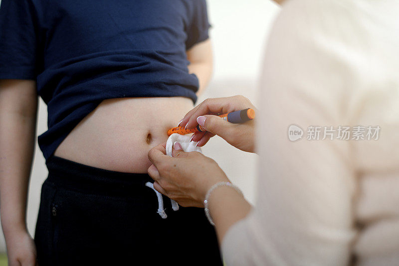一个男孩在胃里注射胰岛素