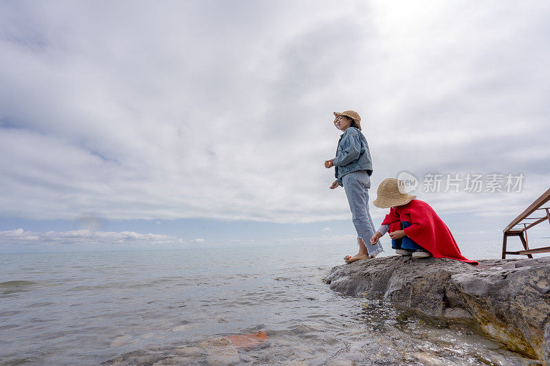 两姐妹在湖边喂鱼