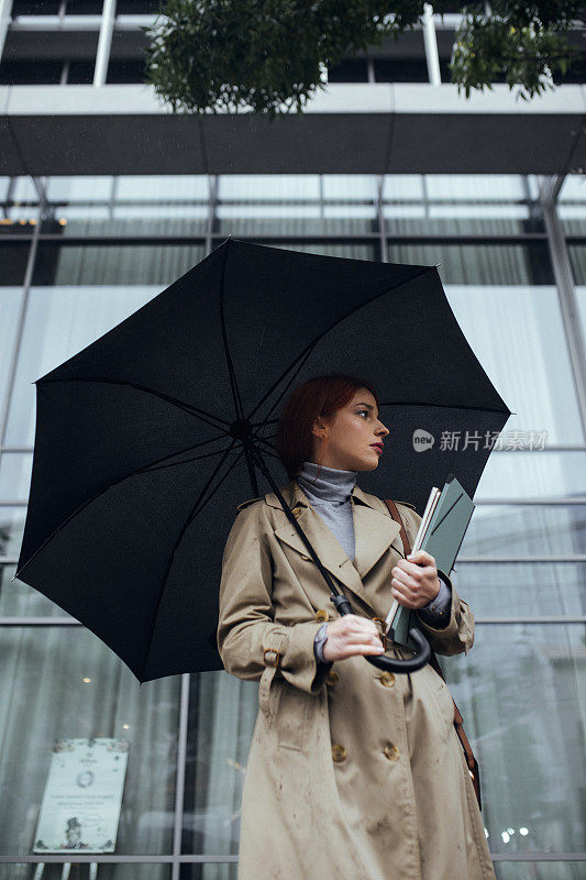 带着雨伞散步的年轻女商人