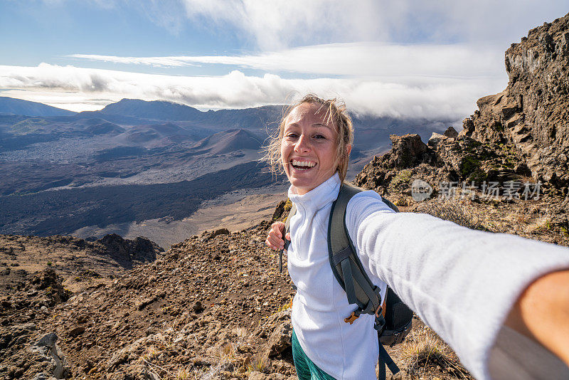 一个快乐的年轻女子在火山上自拍