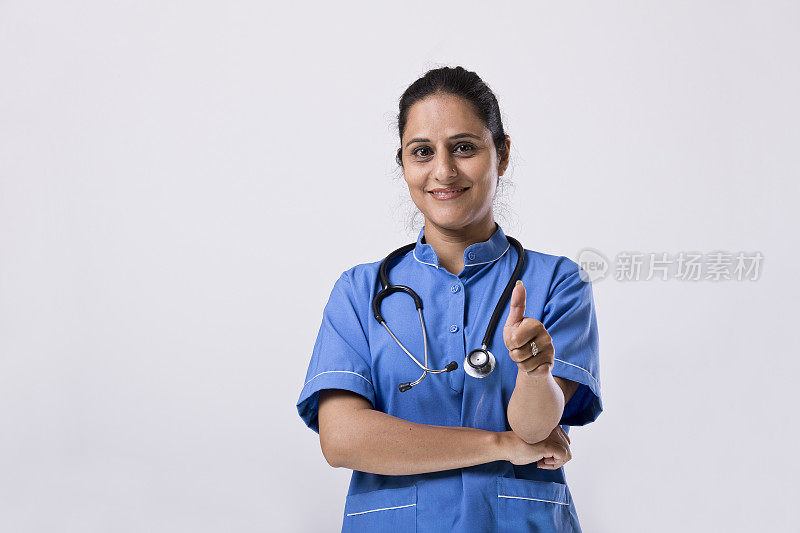 自信的女护士，在白色的背景上竖起大拇指