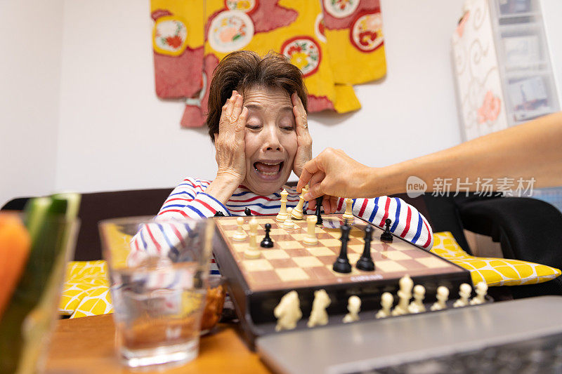 老女人在视频通话下象棋