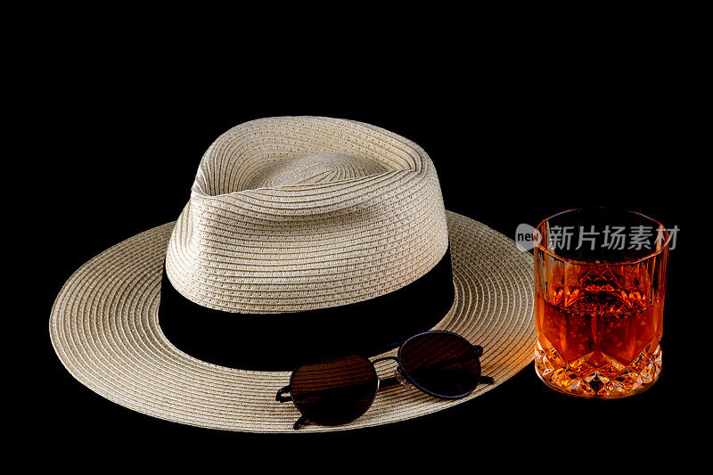 巴拿马草帽，太阳镜，黑色背景上的饮料