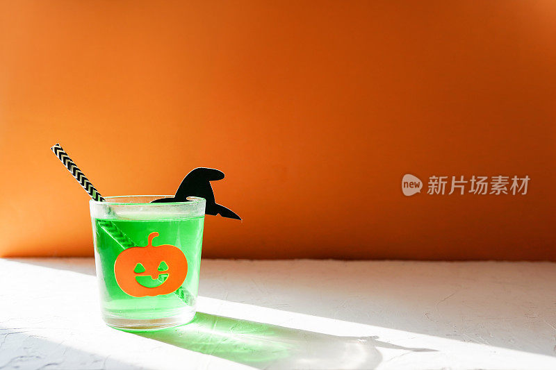 绿色饮料与万圣节南瓜在橙色的背景，复制空间