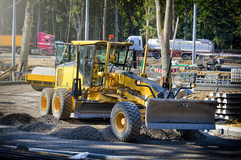 平地机将新公路施工现场的碎石弄平