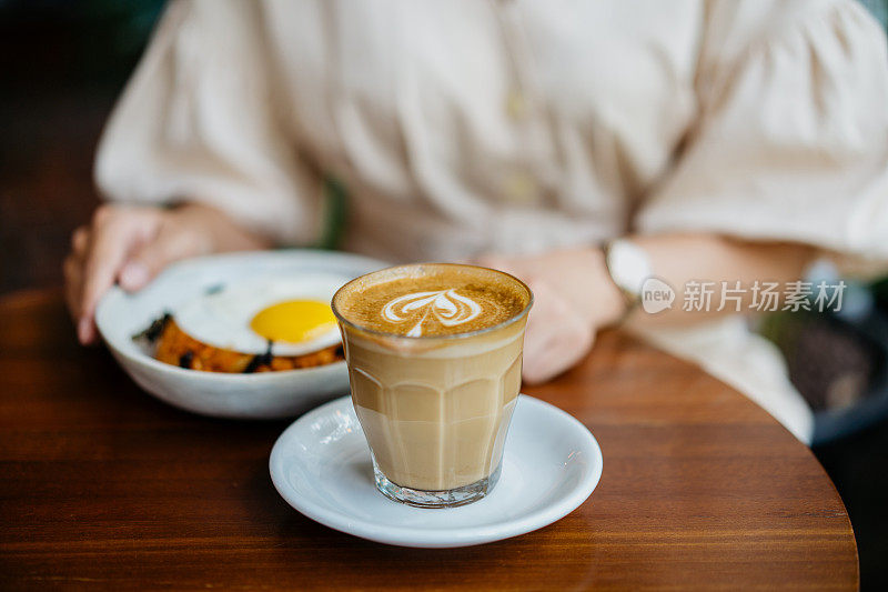 一位亚洲华人女士在咖啡厅喝咖啡和吃午饭